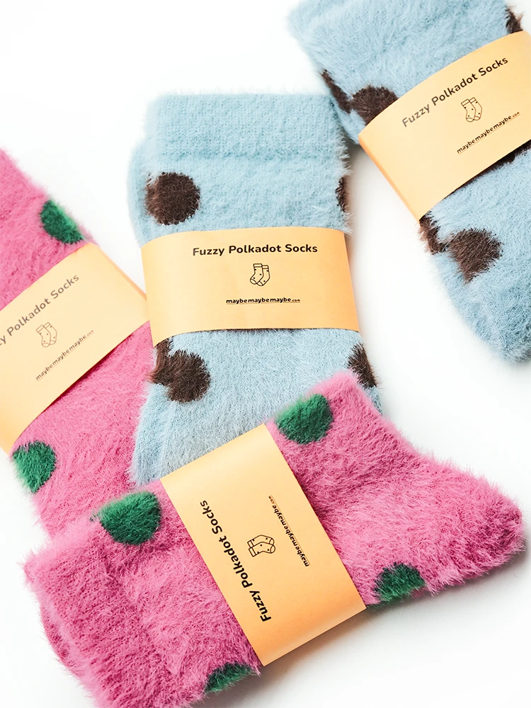 Close-up of multiple pink and sky blue polka dot fuzzy socks