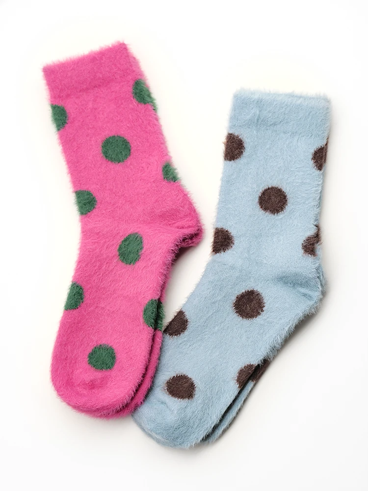 Pink and sky blue polka dot fuzzy socks side by side