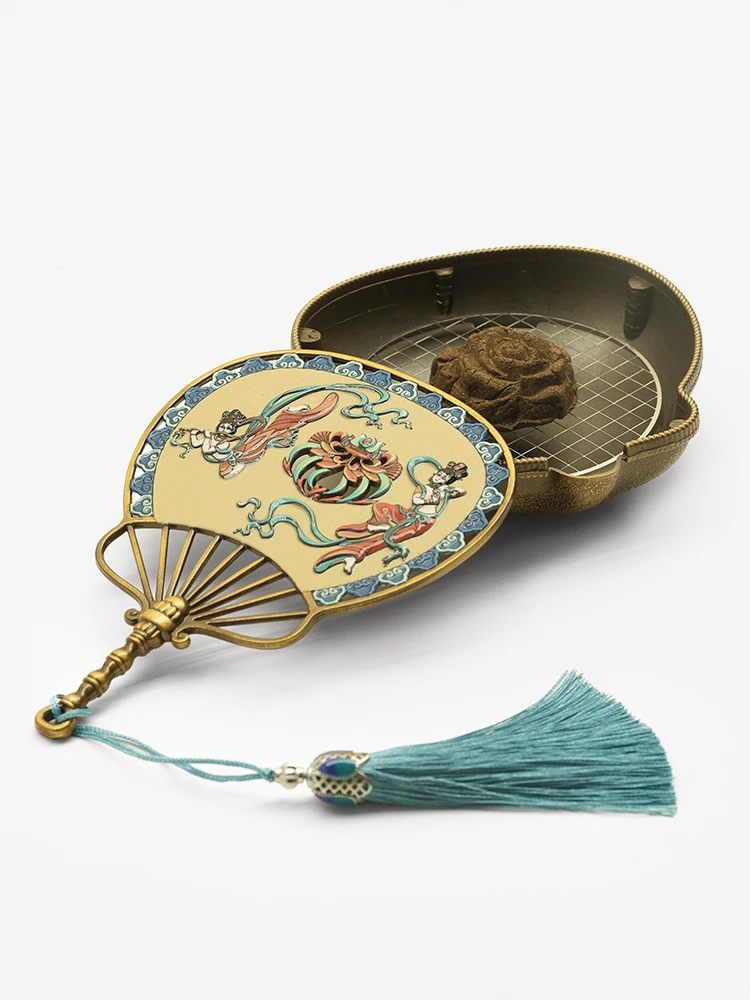 Bronze incense burner open with incense inside
