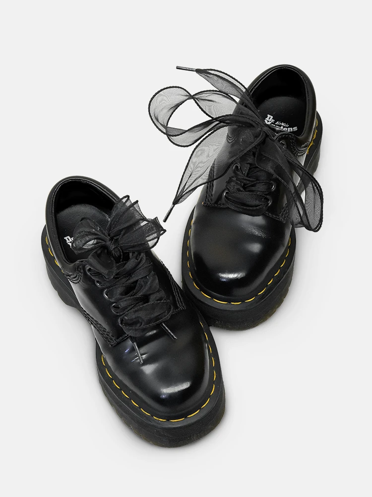 Black wide satin shoelaces on low leather shoes